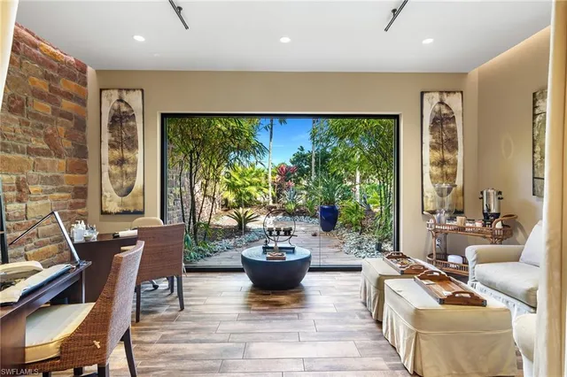 a living room with furniture potted plant and a large window