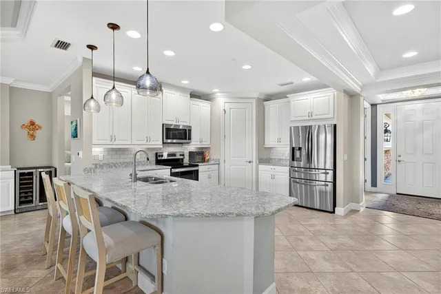 a kitchen with stainless steel appliances granite countertop a sink refrigerator and cabinets