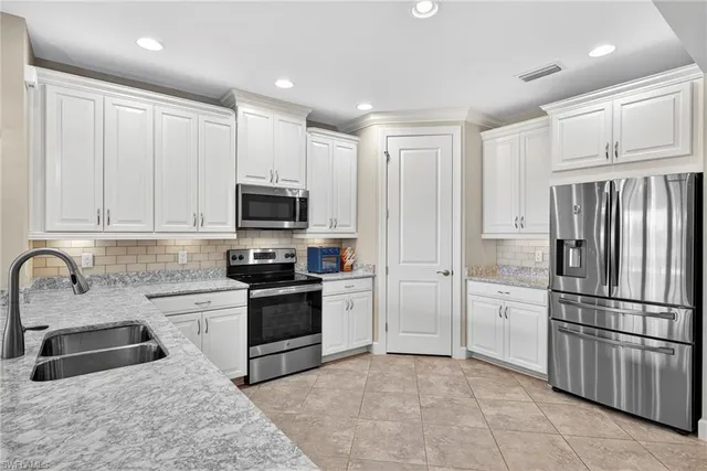 a kitchen with stainless steel appliances granite countertop a refrigerator sink and stove