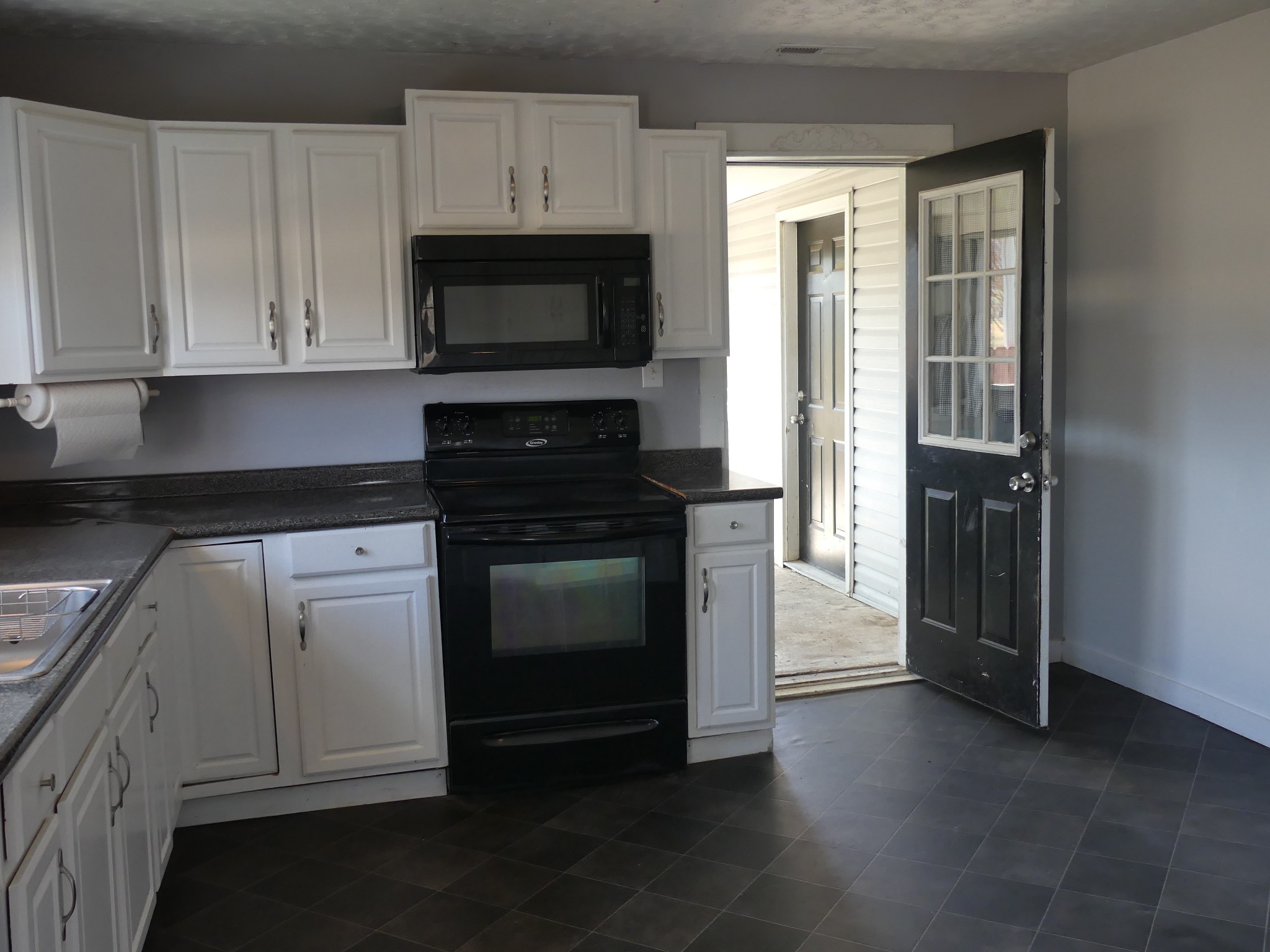231 Mountain Road Elora, TN 37328 - Photo 13 of 32 a kitchen with white cabinets and black appliances