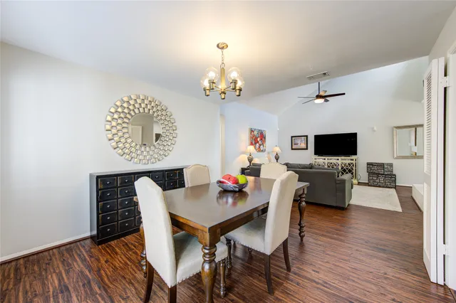 a view of a dining room with furniture a chandelier and wooden floor