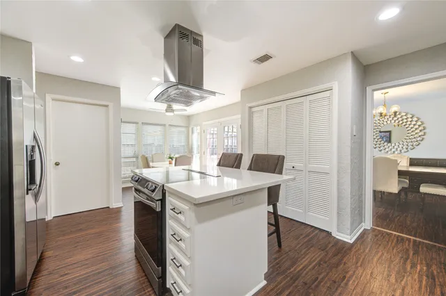 a kitchen with stainless steel appliances granite countertop a sink a stove and a wooden floors