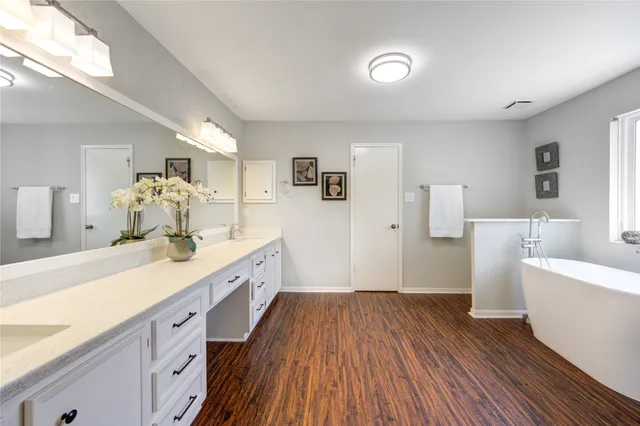 a spacious bathroom with a sink and a large mirror