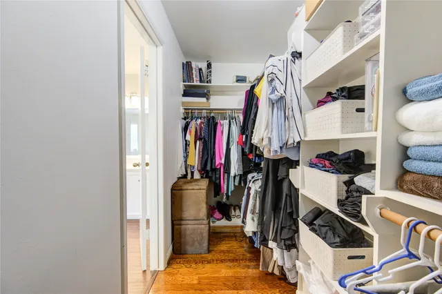 a view of walk in closet with clothes and shoes