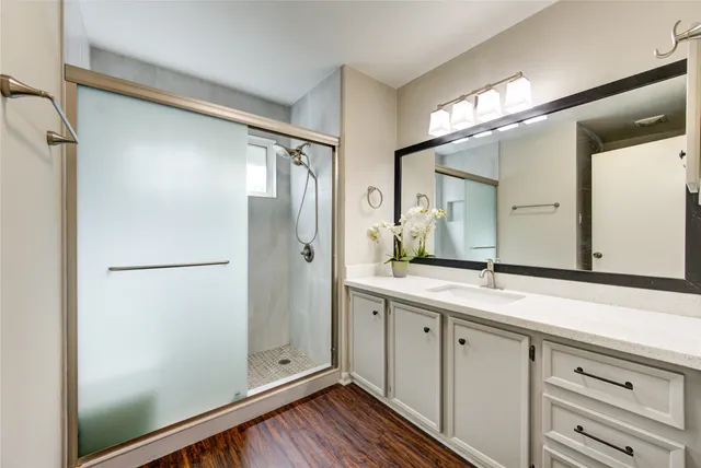 a bathroom with a granite countertop sink mirror and shower