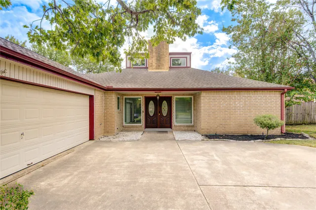 a front view of a house with a garden and trees