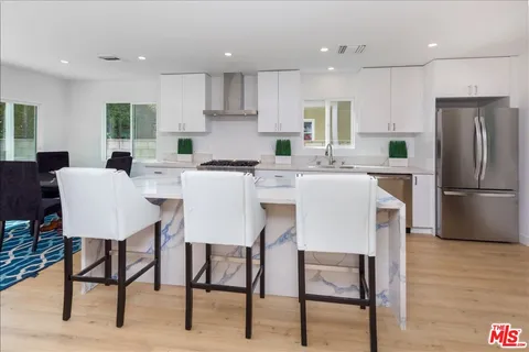 a kitchen with refrigerator a table and chairs