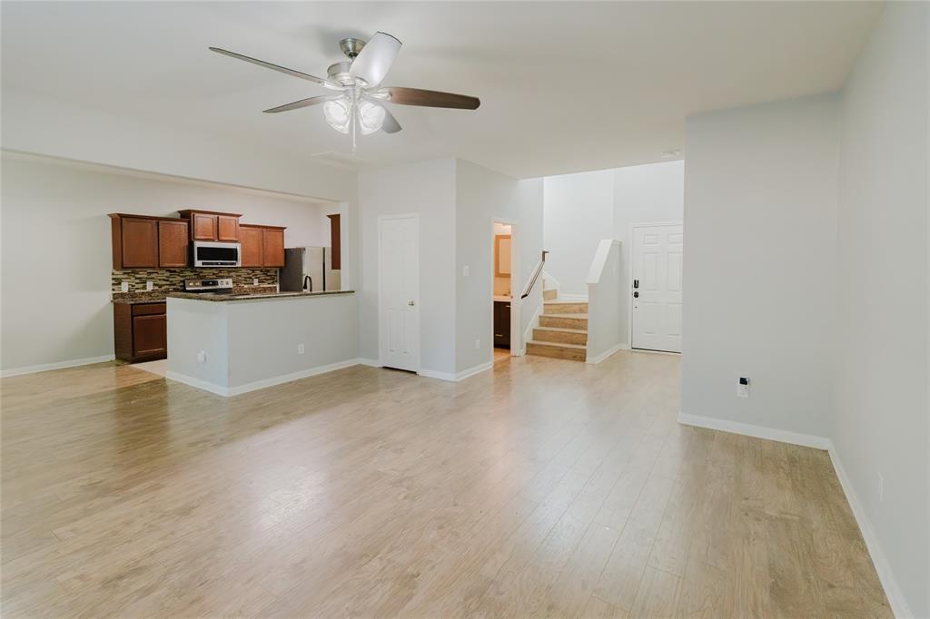 12637 Forest Lawn Road Rhome, TX 76078 - Photo 11 of 31 a view of a kitchen with a stove cabinets a ceiling fan and wooden floor