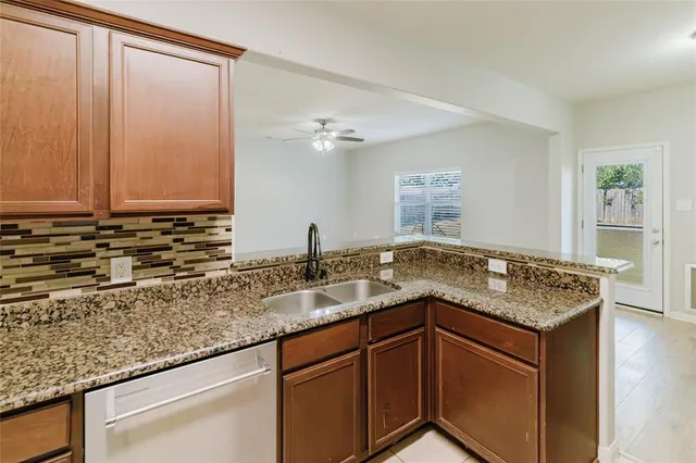 a kitchen with stainless steel appliances granite countertop a refrigerator and a stove