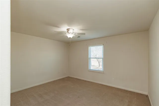 an empty room with a chandelier fan
