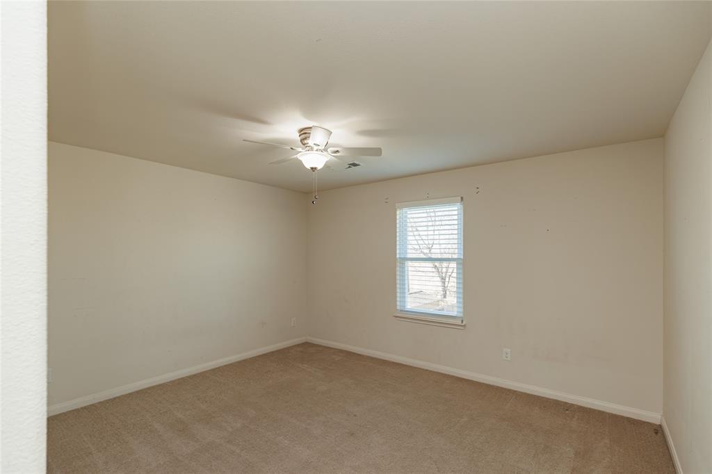12637 Forest Lawn Road Rhome, TX 76078 - Photo 20 of 31 an empty room with a chandelier fan and windows