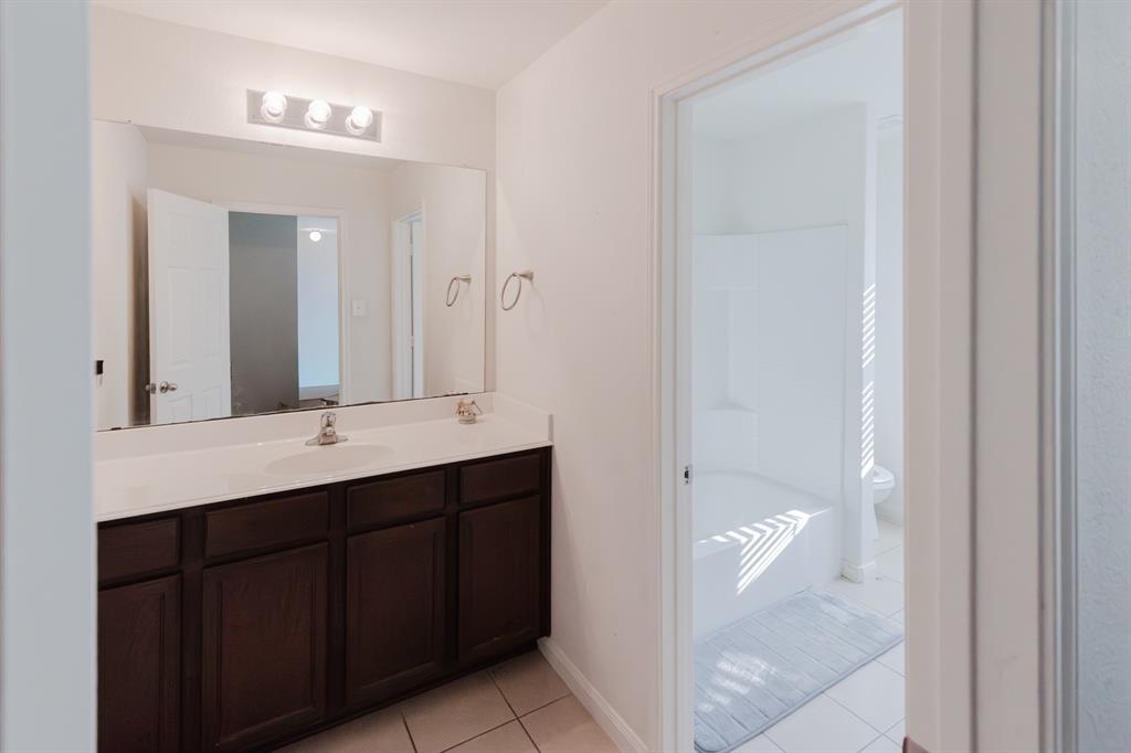 12637 Forest Lawn Road Rhome, TX 76078 - Photo 23 of 31 a bathroom with a double vanity sink and mirror