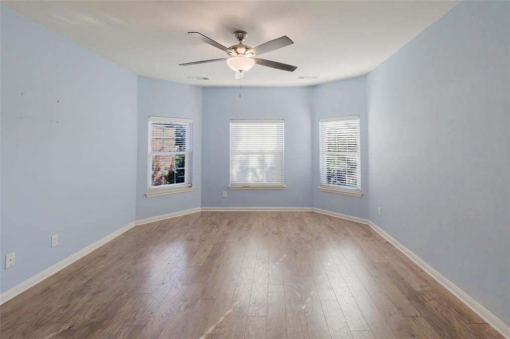 12637 Forest Lawn Road Rhome, TX 76078 - Photo 4 of 31 an empty room with wooden floor and windows