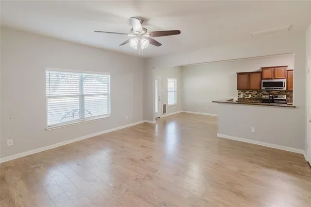a view of a livingroom with furniture a ceiling fan and wooden floor