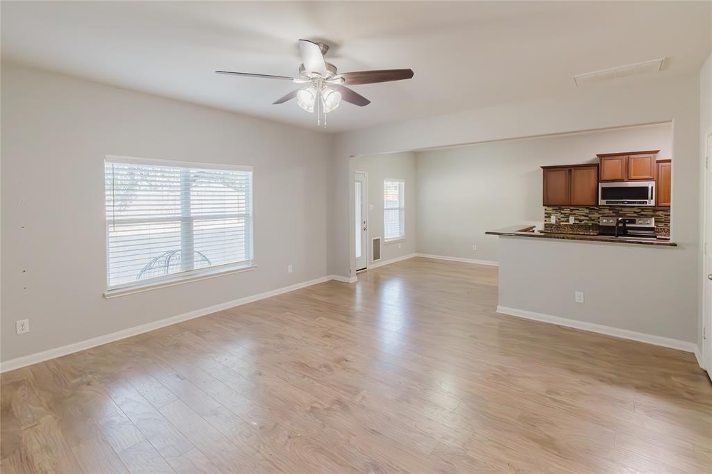 12637 Forest Lawn Road Rhome, TX 76078 - Photo 10 of 31 a view of a livingroom with furniture a ceiling fan and wooden floor