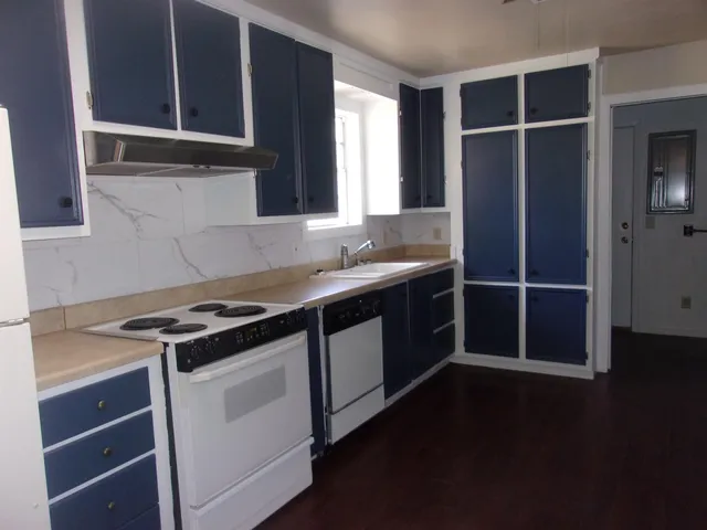 a kitchen with granite countertop a stove and a sink