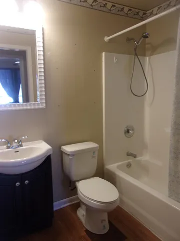 a bathroom with a toilet sink shower and mirror