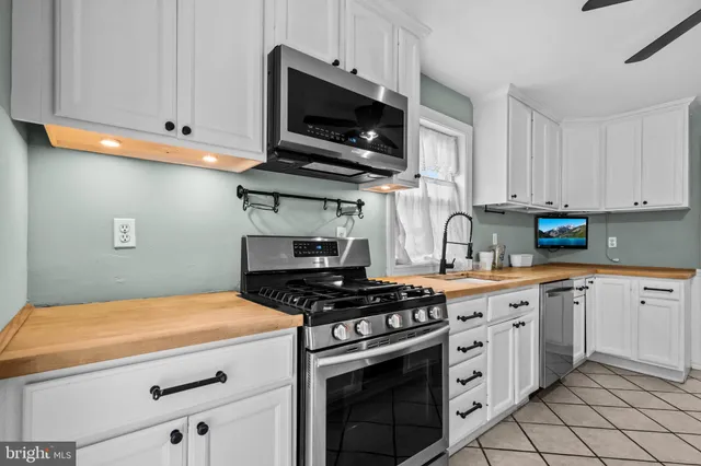 a kitchen with stainless steel appliances a stove a microwave and cabinets