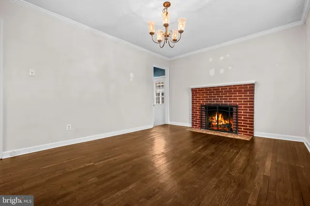 a view of empty room with wooden floor and fireplace