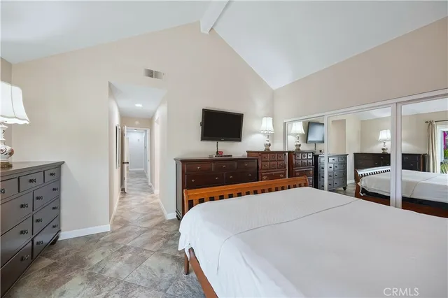 a large bedroom with a bed and a flat screen tv