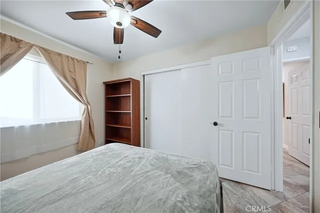 a bedroom with a bed and a chandelier fan