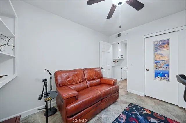 a living room with furniture a ceiling fan and a rug