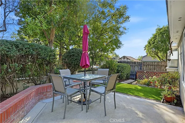 a view of a chairs and table in patio with a wooden fence