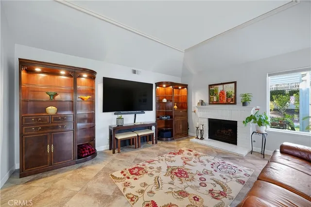 a living room with furniture a flat screen tv and a fireplace