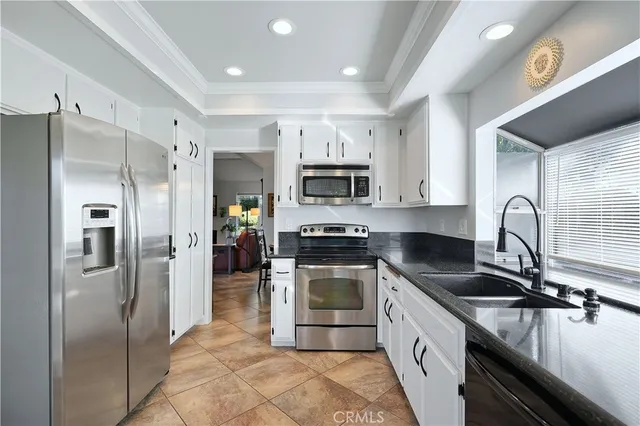 a kitchen with stainless steel appliances granite countertop a refrigerator a stove and a sink with wooden floor