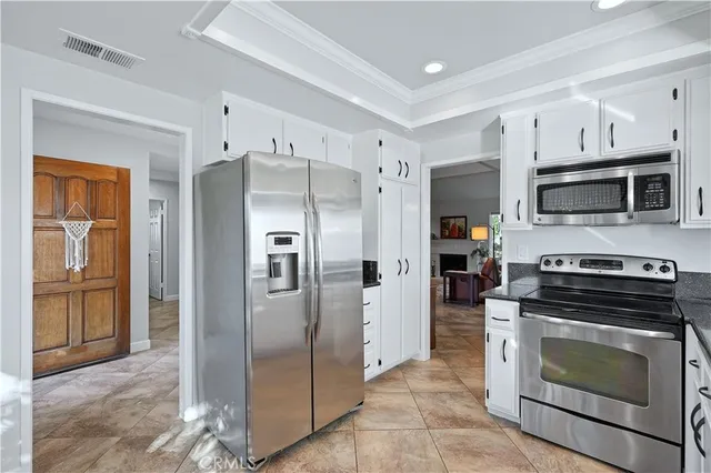 a kitchen with stainless steel appliances granite countertop a refrigerator and a stove top oven