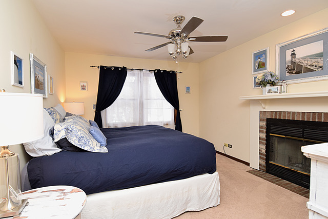 N040 Pierce Avenue Wheaton, IL 60187 - Photo 11 of 20 a bedroom with a bed and a fireplace