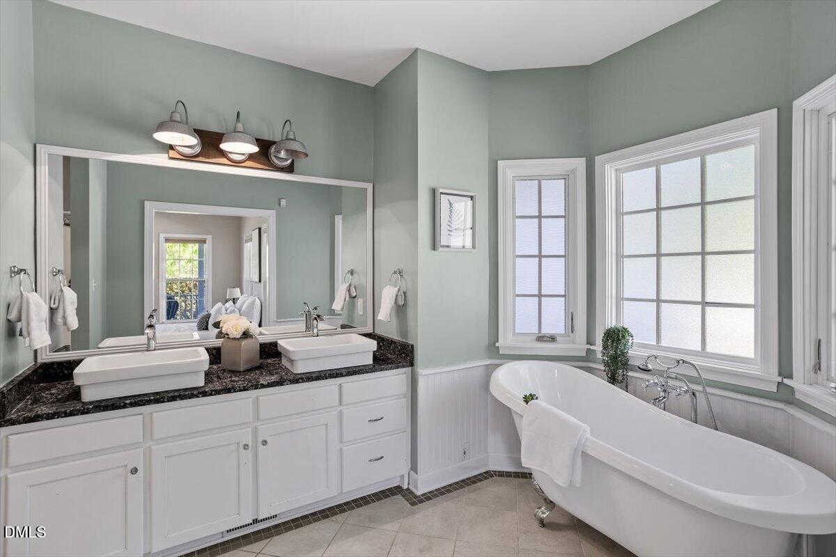 7505 Penny Road Raleigh, NC 27606 - Photo 30 of 35 a bathroom with a tub a double vanity sink and a window