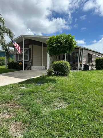 a view of a house with a yard and sitting area
