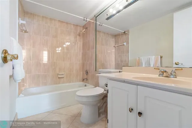 a bathroom with a granite countertop sink a toilet a mirror a bathtub and shower