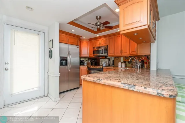 a view of a kitchen with a sink and a refrigerator