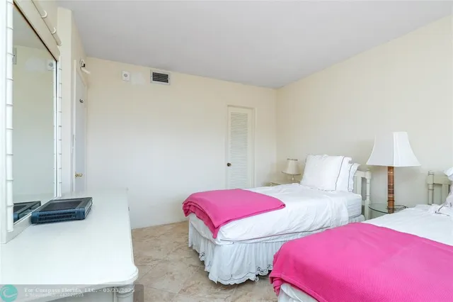 a bedroom with two beds and a lamp