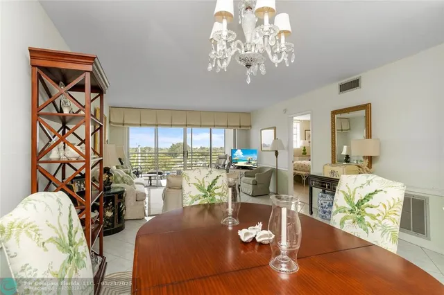 a view of a dining room with furniture a chandelier and wooden floor