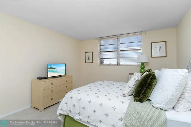 a bedroom with a bed and a flat tv screen on the dresser