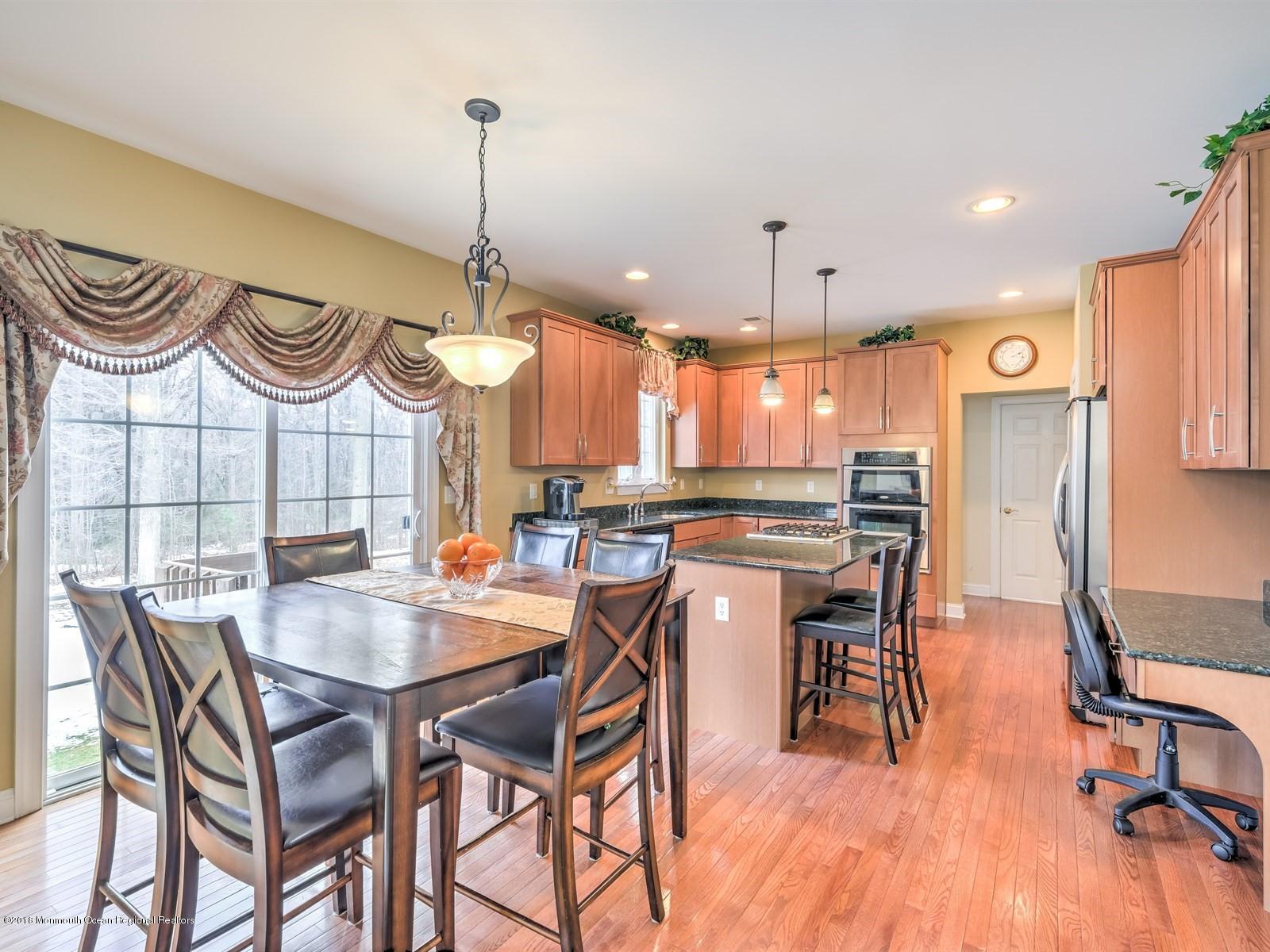 20 Emily Road Manalapan, NJ 07726 - Photo 8 of 25 a kitchen with stainless steel appliances granite countertop a kitchen island a stove a table and chairs