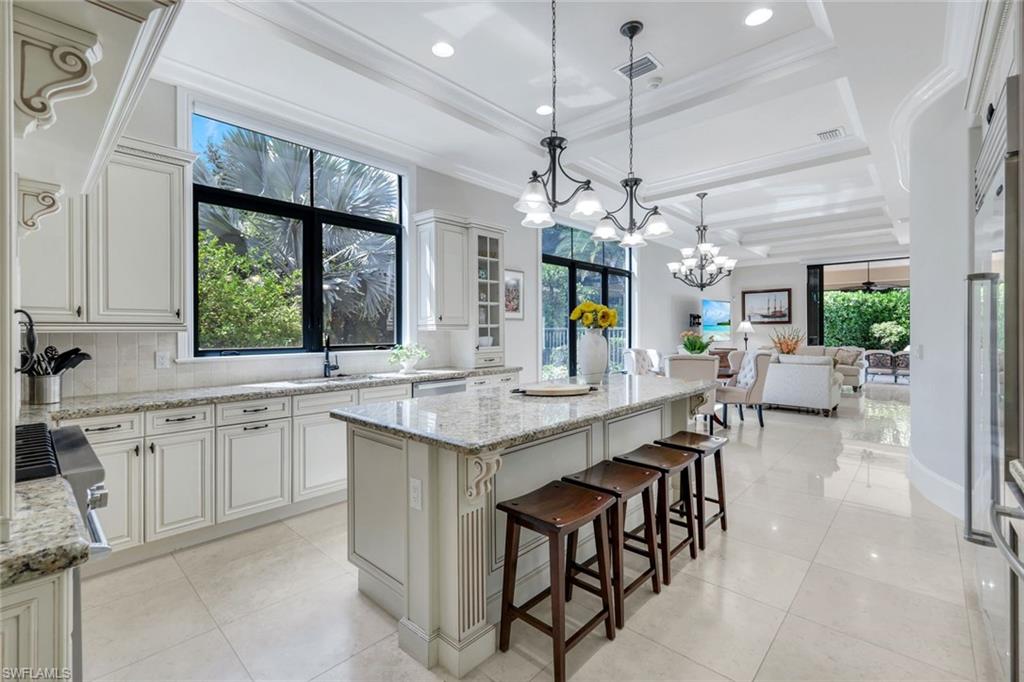 2351 Traditions Court Naples, FL 34105 - Photo 12 of 48 a large kitchen with a counter space a sink and living room view