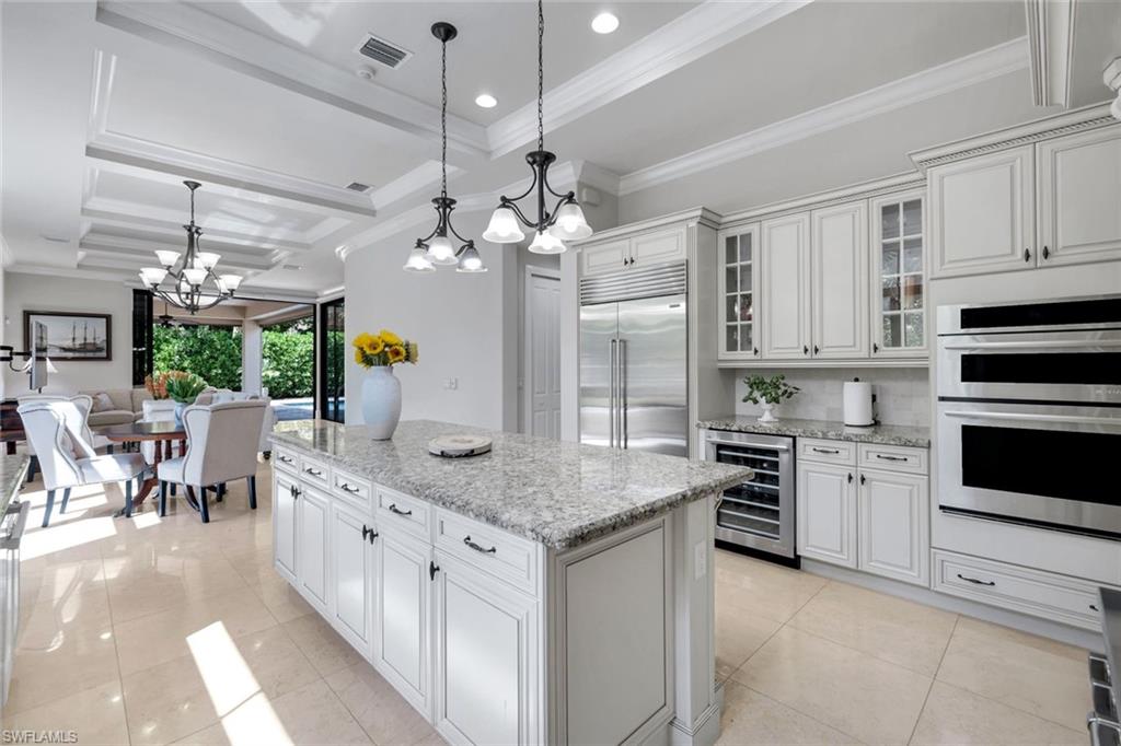 2351 Traditions Court Naples, FL 34105 - Photo 13 of 48 a kitchen that has a lot of cabinets in it