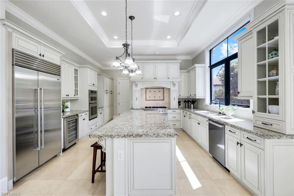 2351 Traditions Court Naples, FL 34105 - Photo 16 of 48 a large kitchen with kitchen island granite countertop a large counter top appliances and cabinets