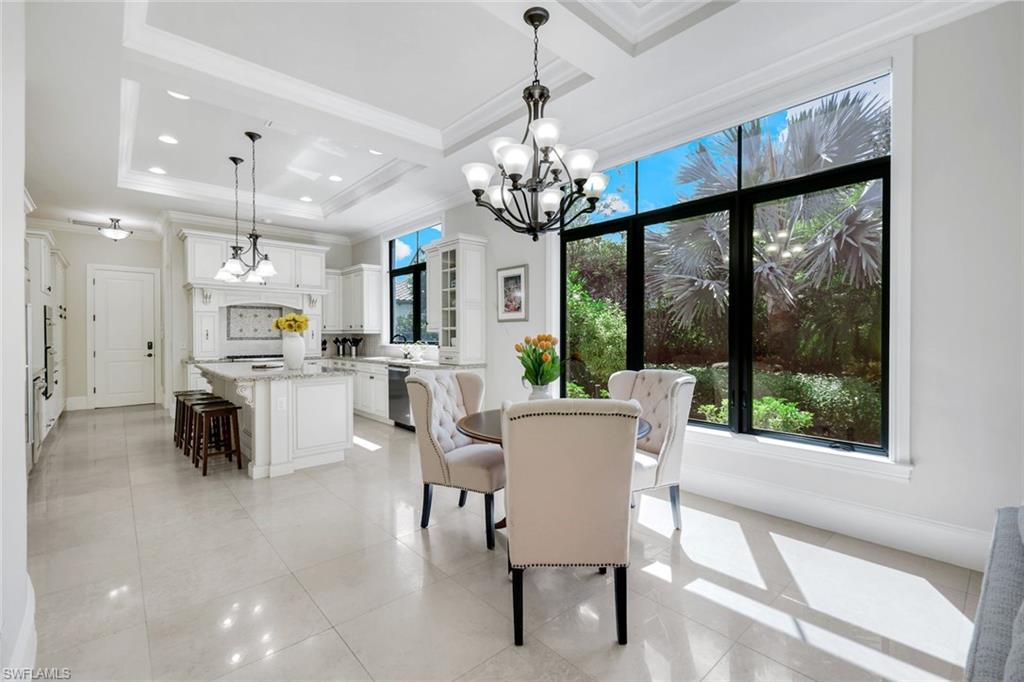 2351 Traditions Court Naples, FL 34105 - Photo 17 of 48 a view of a dining room with furniture large windows and a chandelier