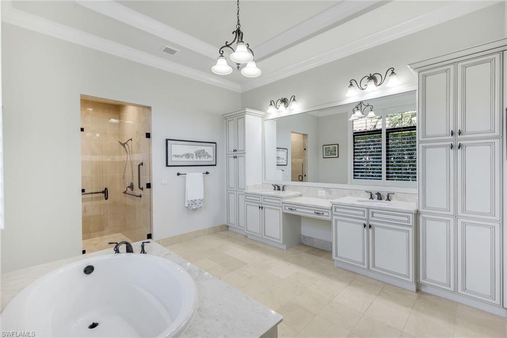 2351 Traditions Court Naples, FL 34105 - Photo 28 of 48 a bathroom with a tub a double vanity sink a window and a mirror