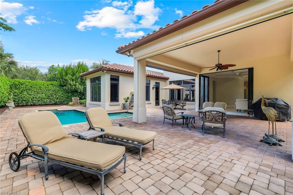 2351 Traditions Court Naples, FL 34105 - Photo 42 of 48 a view of a patio with a dining table and chairs with wooden floor