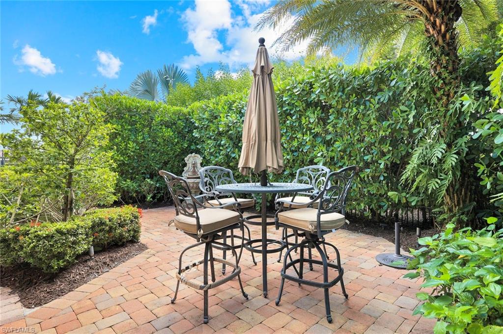 2351 Traditions Court Naples, FL 34105 - Photo 43 of 48 a view of a chairs and table in a backyard