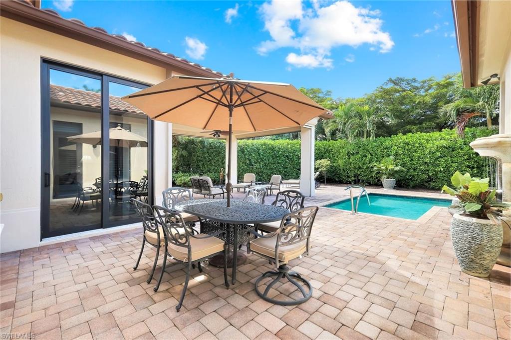 2351 Traditions Court Naples, FL 34105 - Photo 46 of 48 a view of a patio with a table and chairs under an umbrella