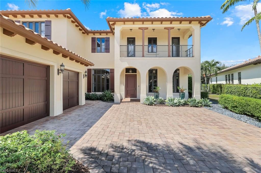 2351 Traditions Court Naples, FL 34105 - Photo 48 of 48 a view of a white house with large windows and a yard
