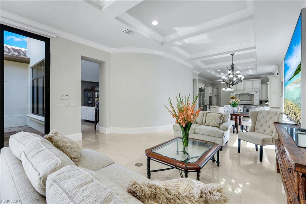 2351 Traditions Court Naples, FL 34105 - Photo 10 of 48 a living room with furniture and a chandelier
