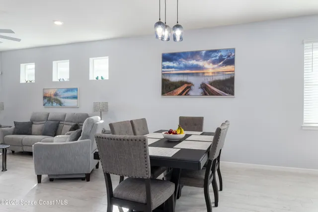 a view of a dining room with furniture a chandelier and wooden floor